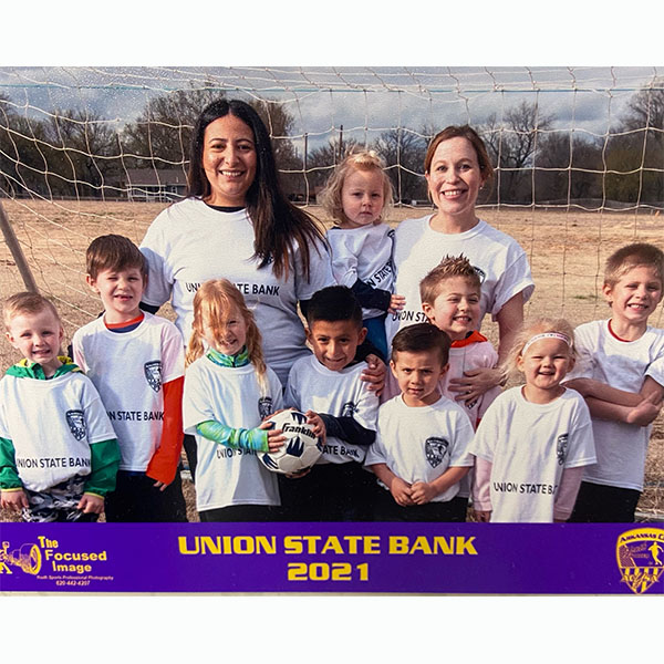 Photo of a little league soccer team with text: Union State Bank 2021, Arkansas City Youth Soccer Association, photo by The Focused Image Photography.