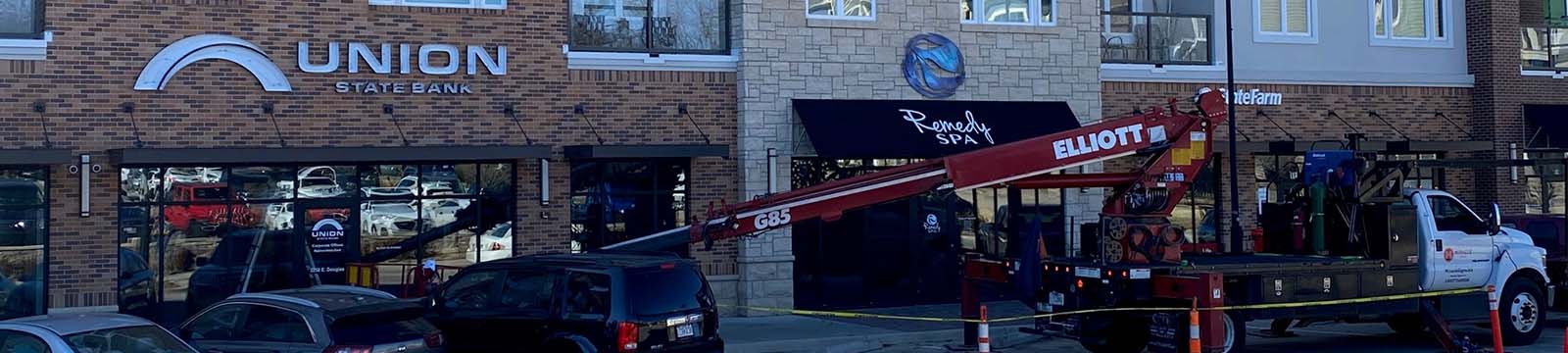 Photo of a lift truck installing new signage in front of a Union State Bank location.