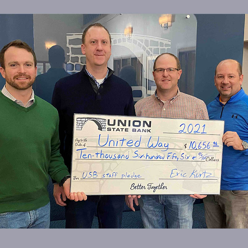 Photo of Union State Bank staff Jesse Morris, Cory Helmer, Brad Bryant, and Eric Kurtz holding an oversized check made out to United Way for $10,656.