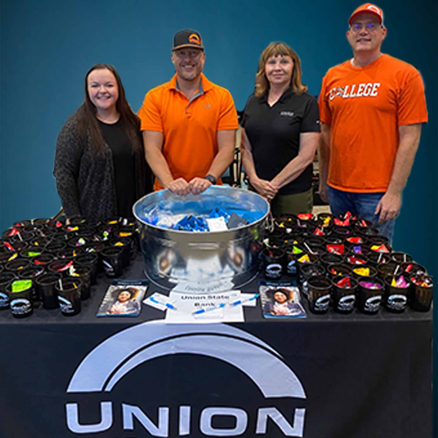 Photo of Union State Bank staff posing behind a table covered with promotional products.