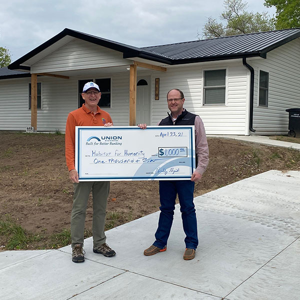 Photo of Union State Bank Market President Brad Bryant and Arkansas City Habitat for Humanity representative Curt Freeland holding an oversized check for $1,000.