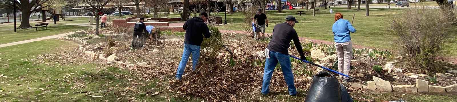Photo of Union State Bank staff raking leaves in a park as part of Bill Docking Day.