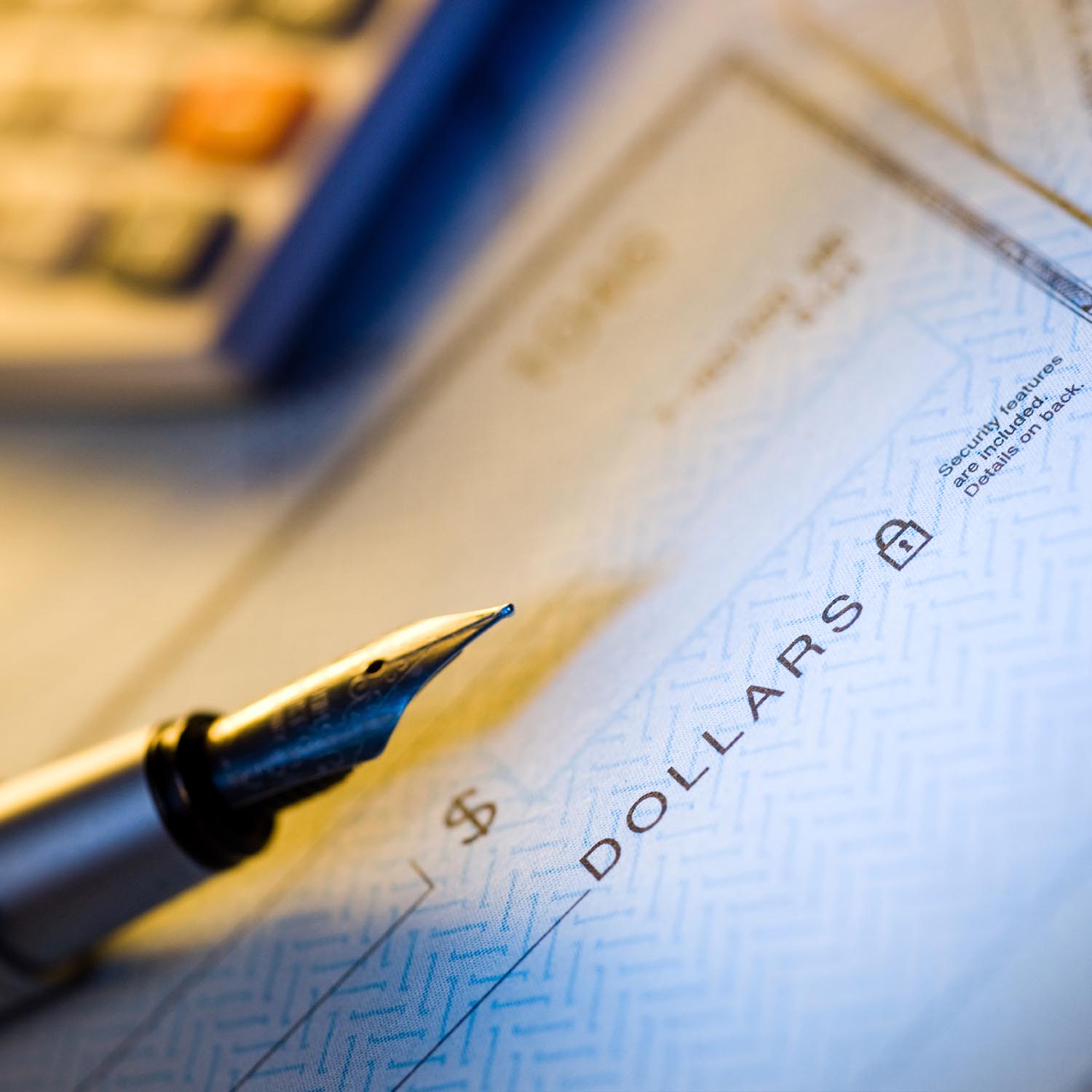 Photo of an ink pen on top of a blank check.