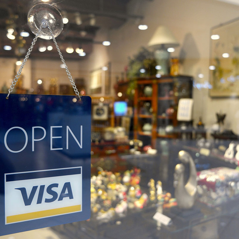 Image of store front looking through window with an open sign.