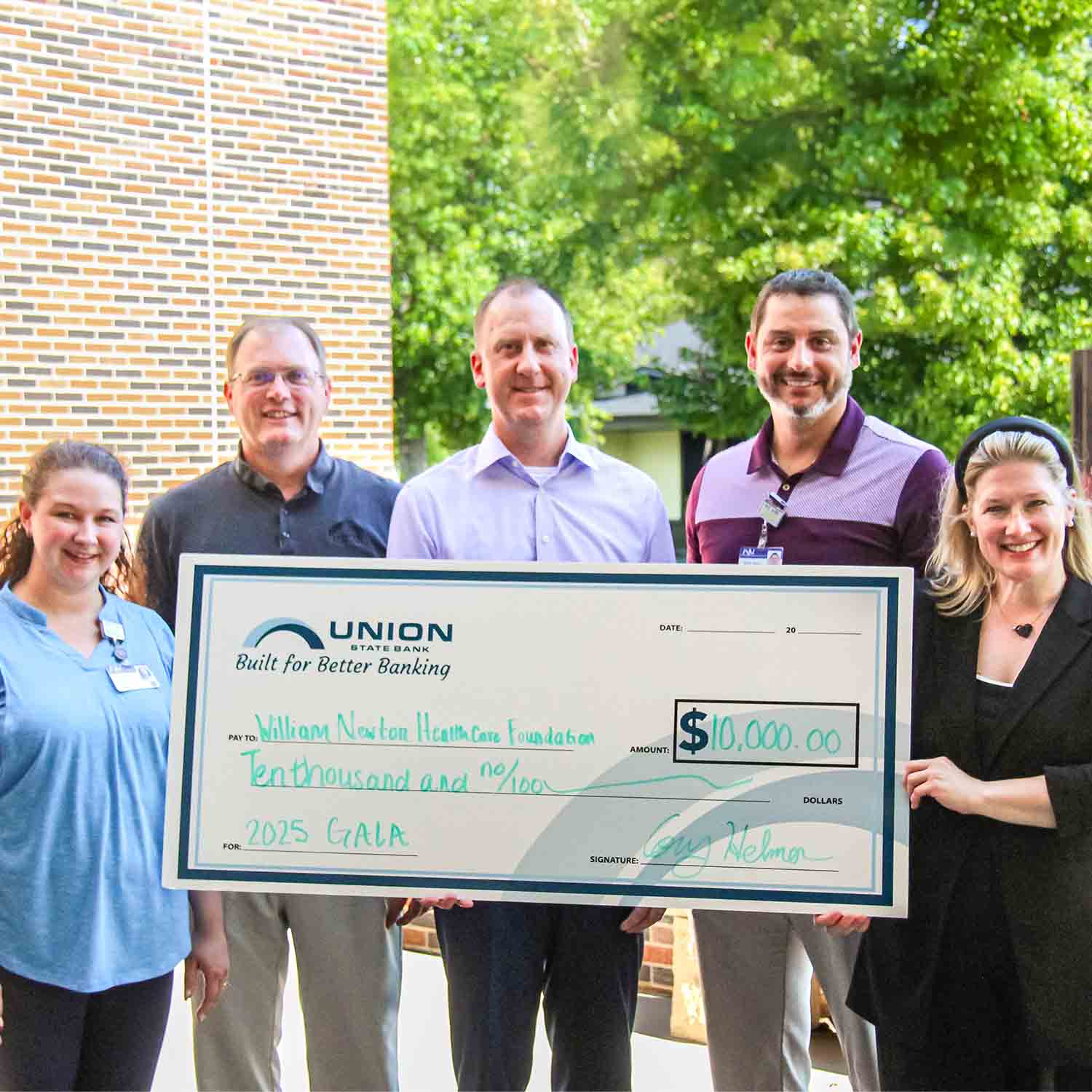 Group photo of WNH Foundation and USB staff presenting the 2025 gala sponsorship check.
