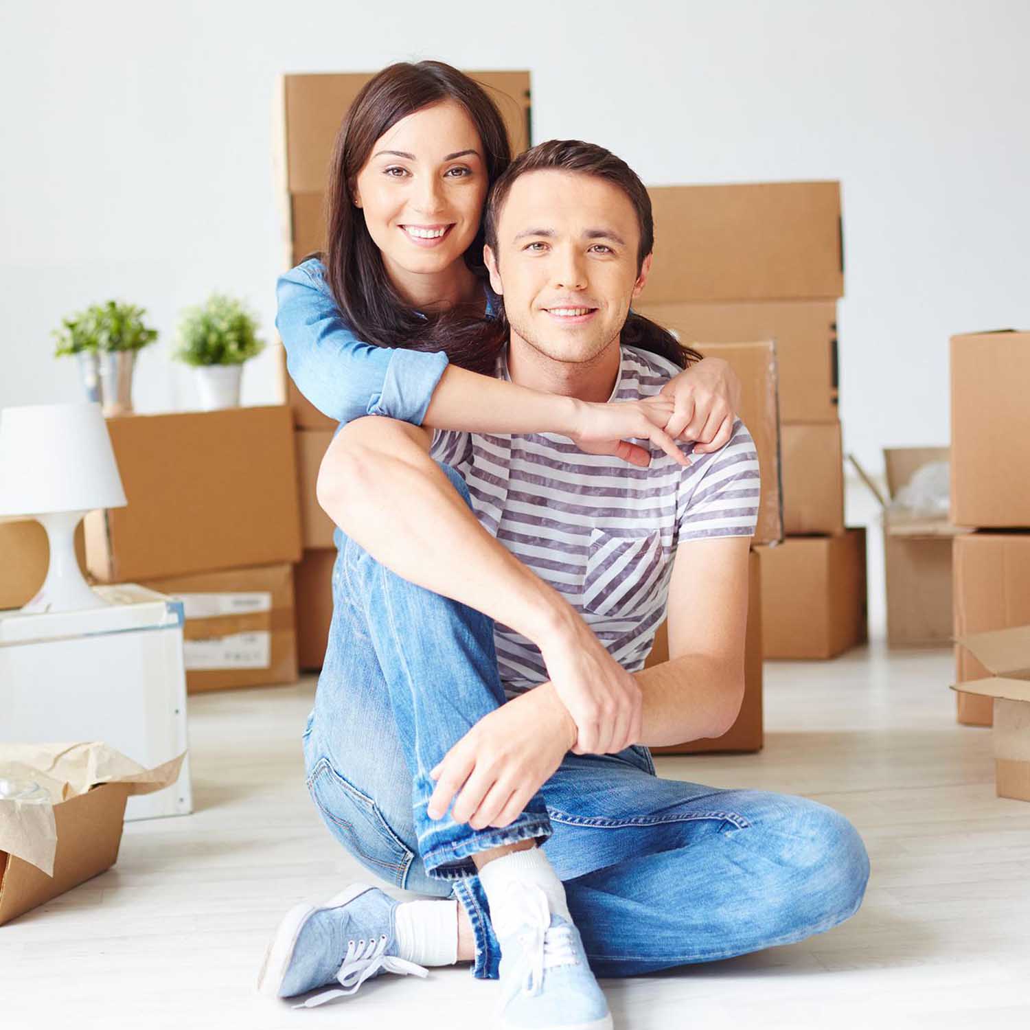 Photo of young couple surrounded by unpacked moving boxes.