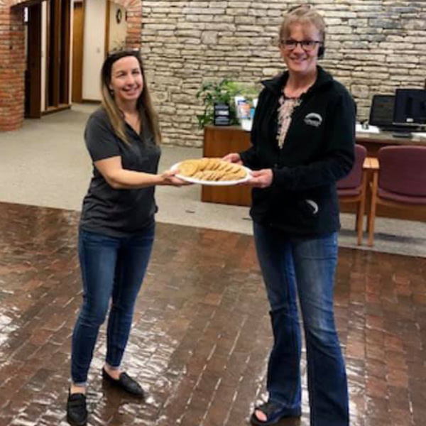 Staff from the Newton main location holding a plate of cookies.