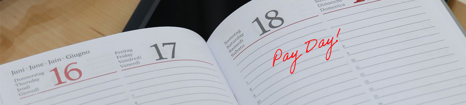 Image of a calendar planner with the words "Pay Day" written over a date.