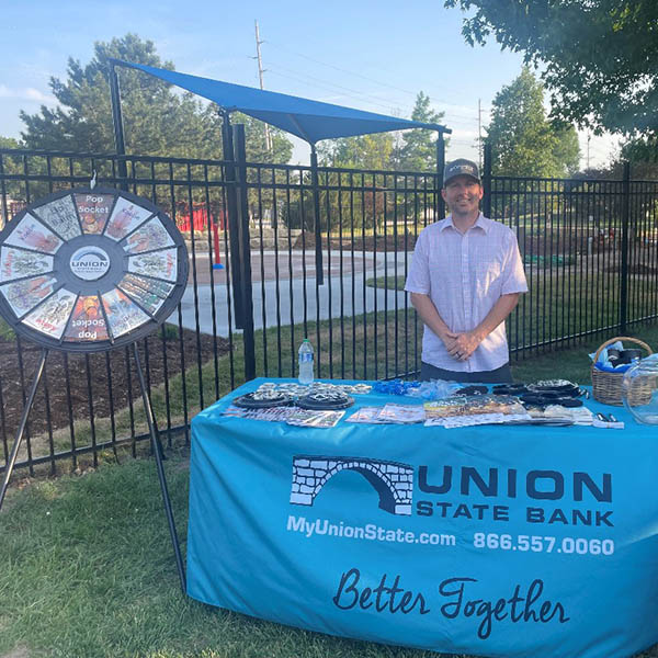 Photo of Rusty at the Union State Bank booth during the ReMax customer appreciation event in Winfield.