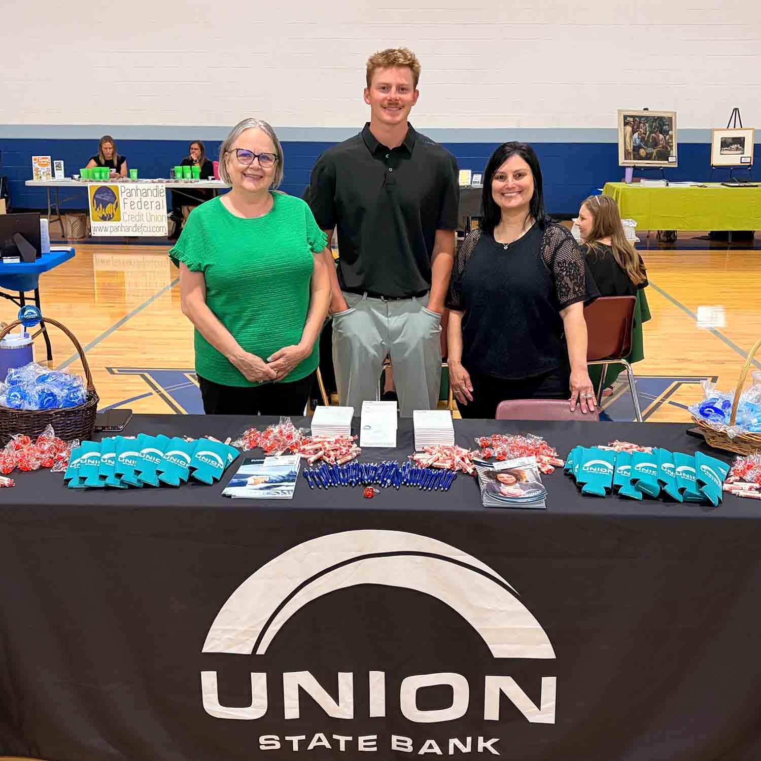 Photo of Union State Bank staff behind a table of promotional items