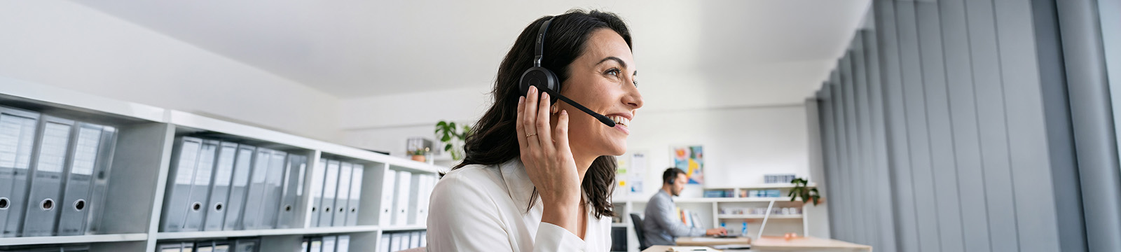 Image of an office worker speaking through a headset.