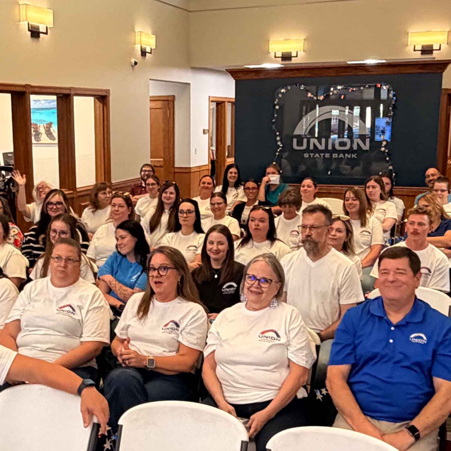 Photo of bank staff sitting together at Union State Bank's Quarterly Celebration event.