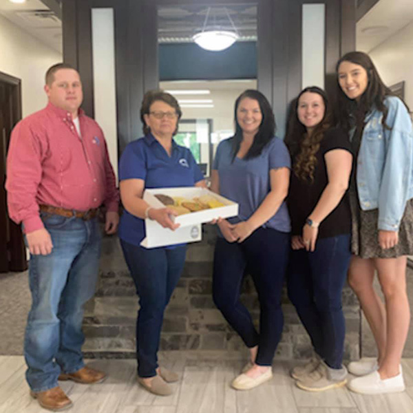 The Bartlesville location staff holding a plate of cookies.