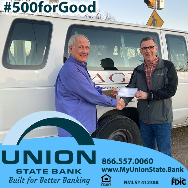 Union State Bank Senior Vice-President Tim Holt (pictured right) presents a member of the Eagle Recovery team with a donation while assisting with serving the area homeless population.