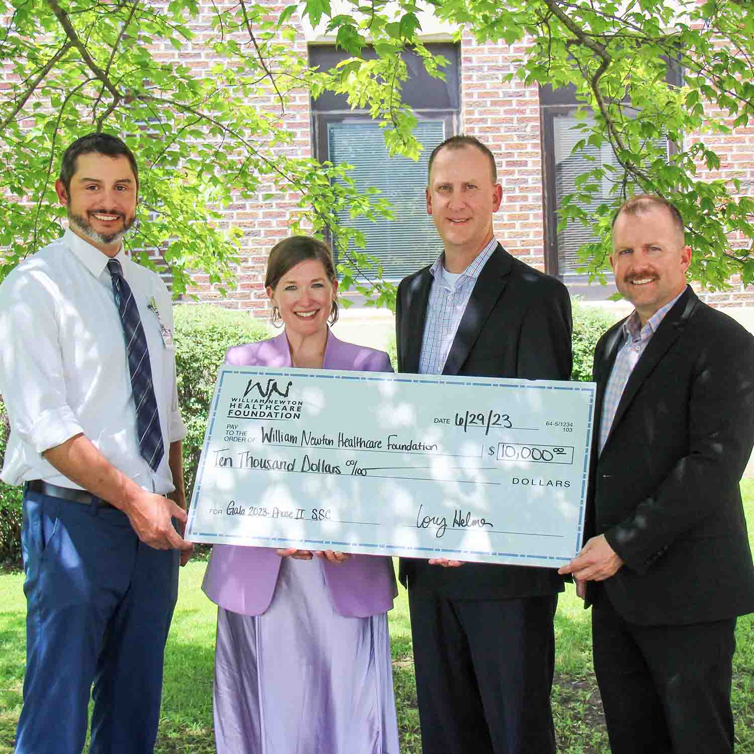 Photo of Rusty Zimmerman and Cory Helmer of Union State Bank holding an oversized check with William Newton Hospital and Foundation staff.