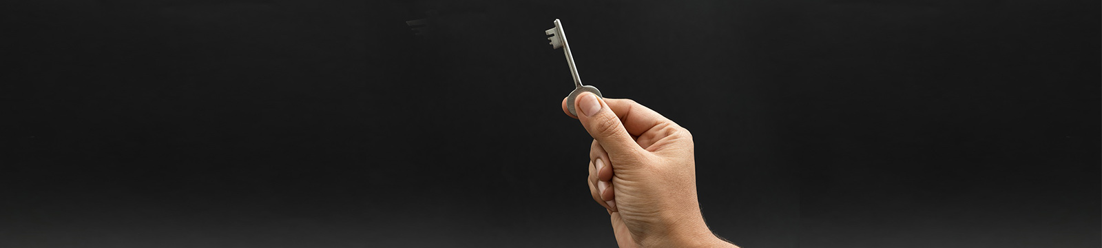 Photo of a hand holding an old fashioned key.