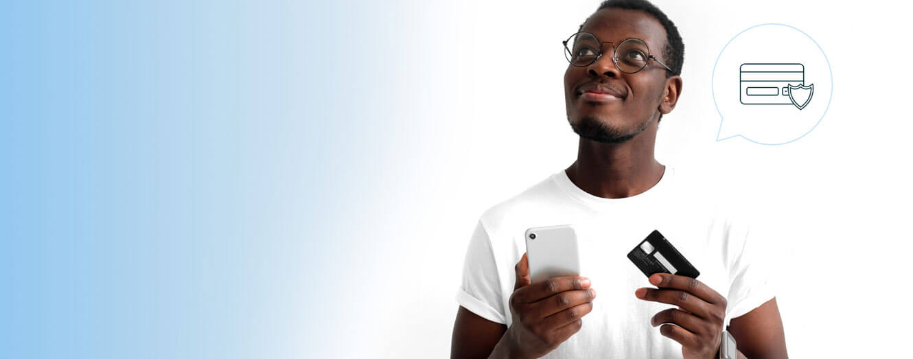Image of man holding bank card and mobile phone looking upward