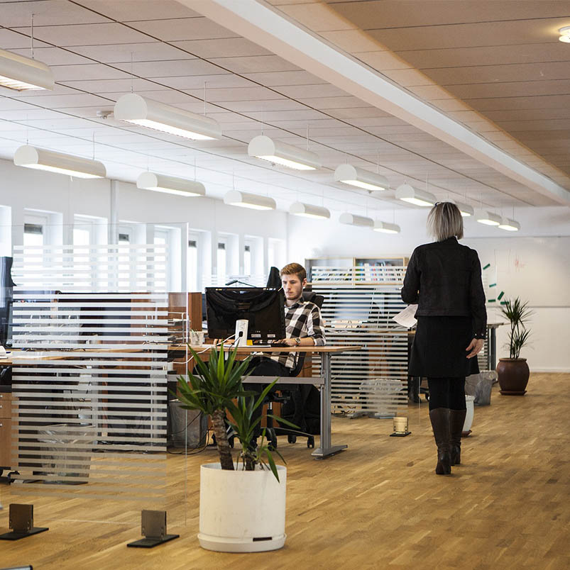 Image of an office suite with staff and open work stations.